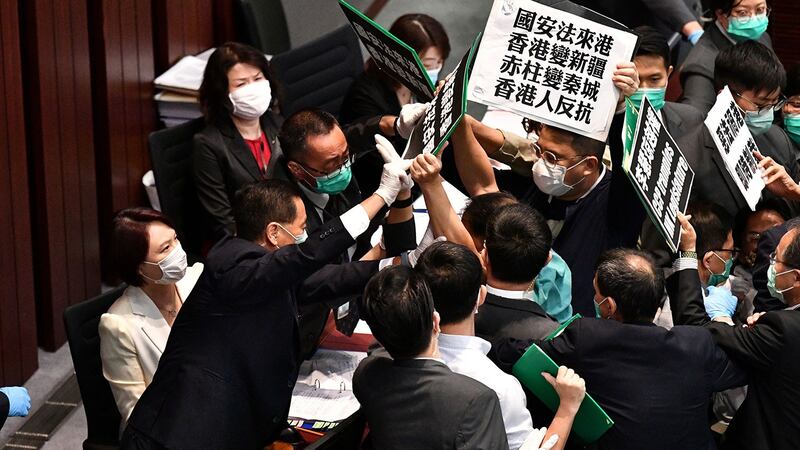 资料图片:2020年5月22日,香港立法会泛民主派议员在内务委员会的一个会议期间举牌抗议北京强推“港版国安法”,他们被保安阻拦。(法新社)